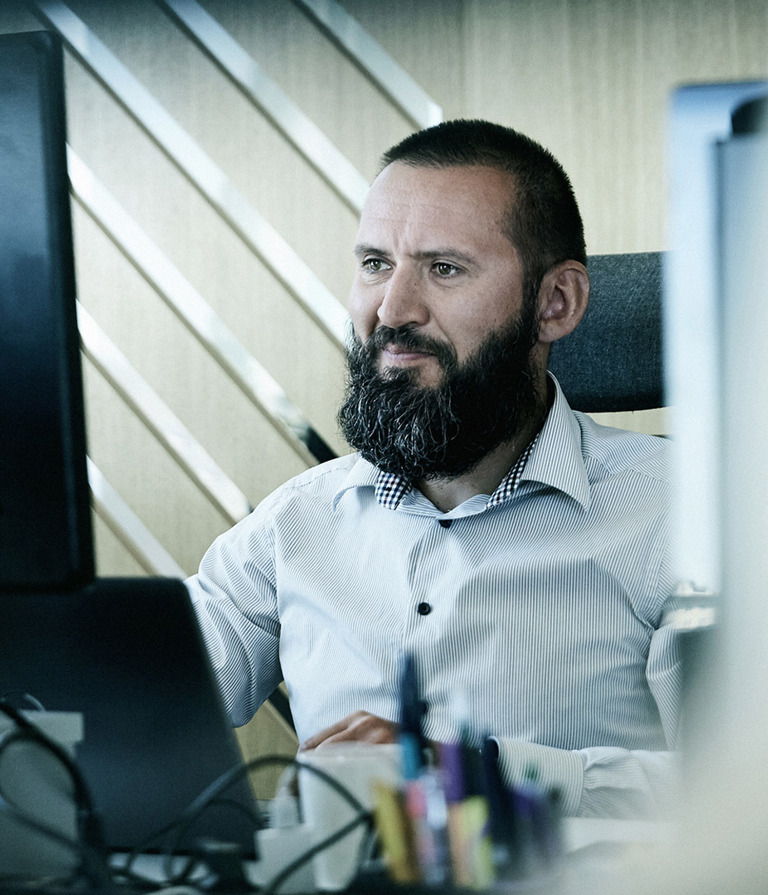 A man looking at a computer while working at the office 