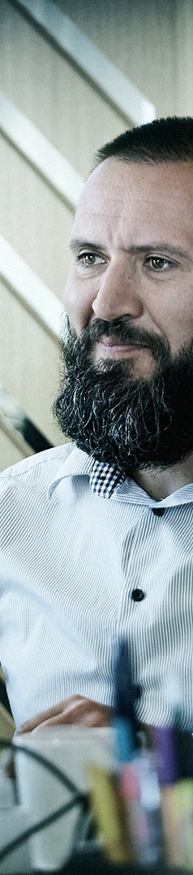 A 7N male staff member looking at a computer while working at the office