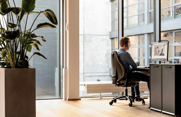 A 7N male staff member on a Zoom call at his computer in the Aarhus office in Denmark. 