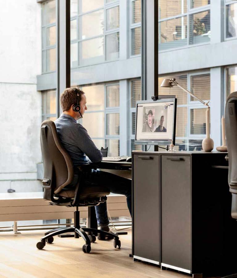 A 7N male staff member on a Zoom call at his computer in the Aarhus office in Denmark. 