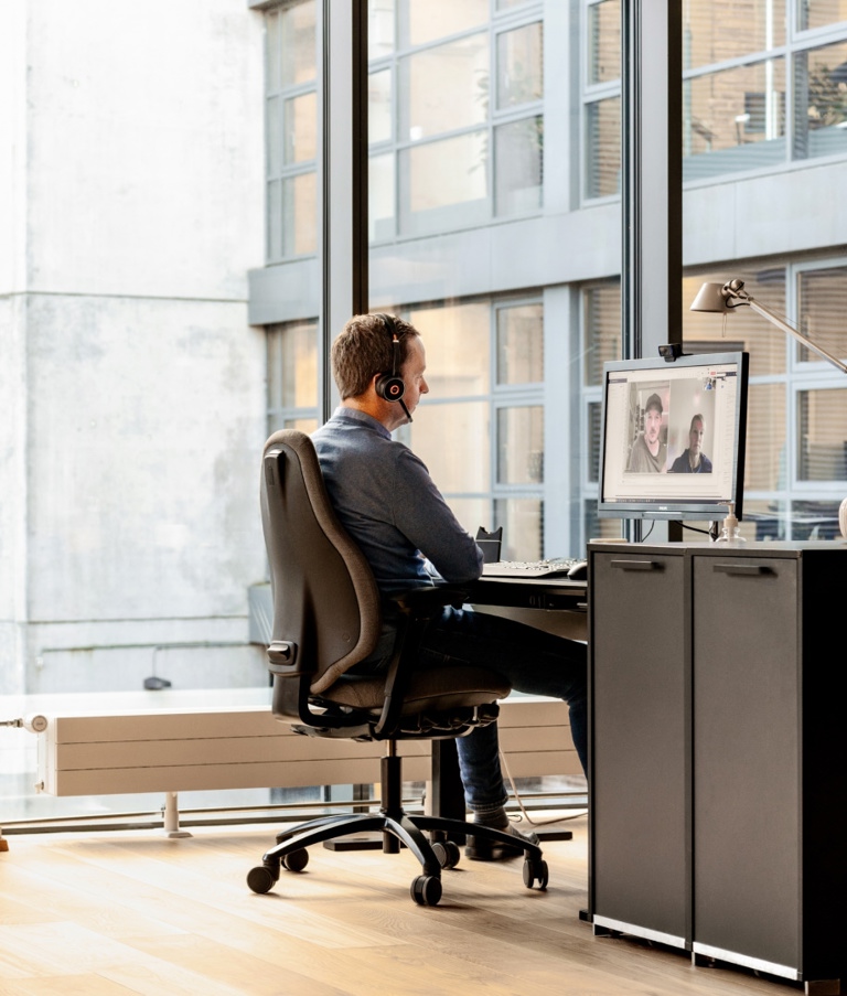 A 7N male staff member on a Zoom call at his computer