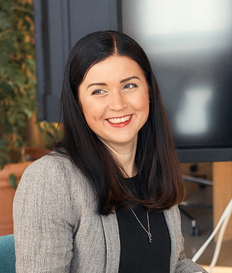 Woman in the Helsinki office smiling at another woman. 