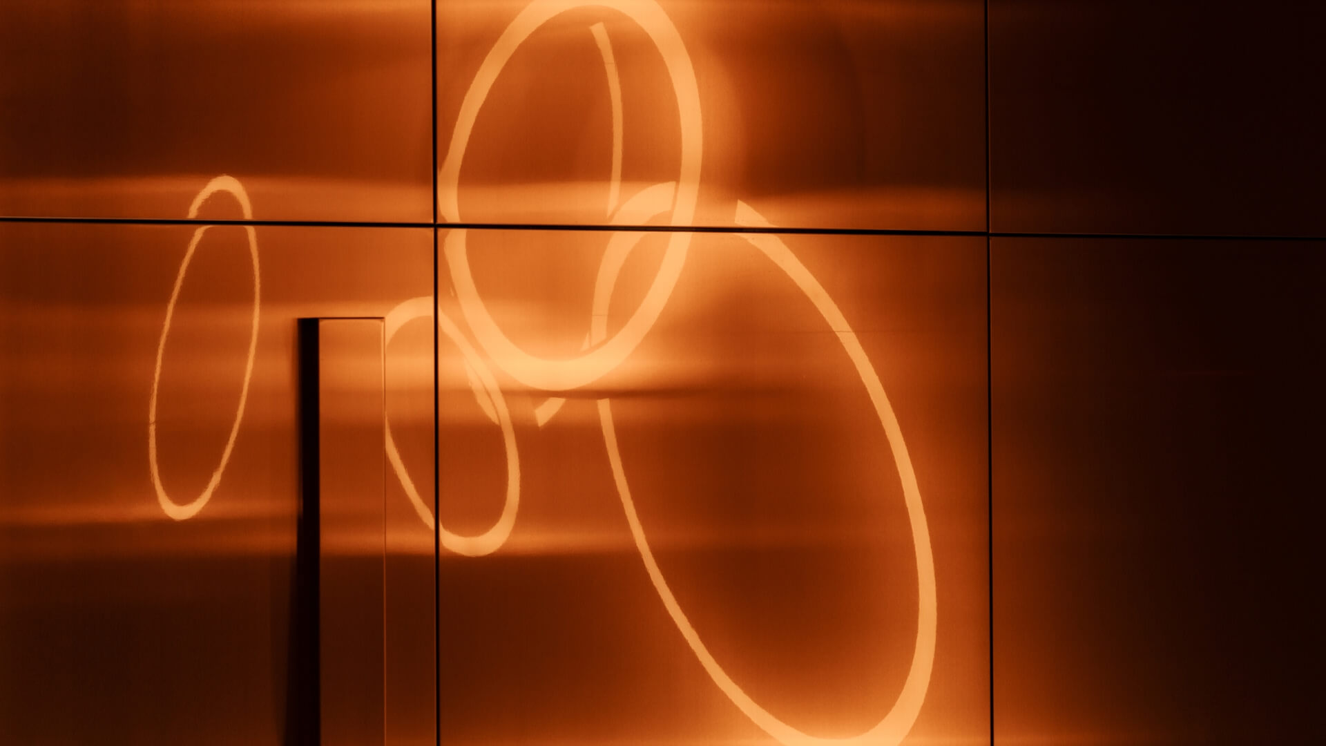 Orange light circles on a wall at the Gdansk Office in Poland. 