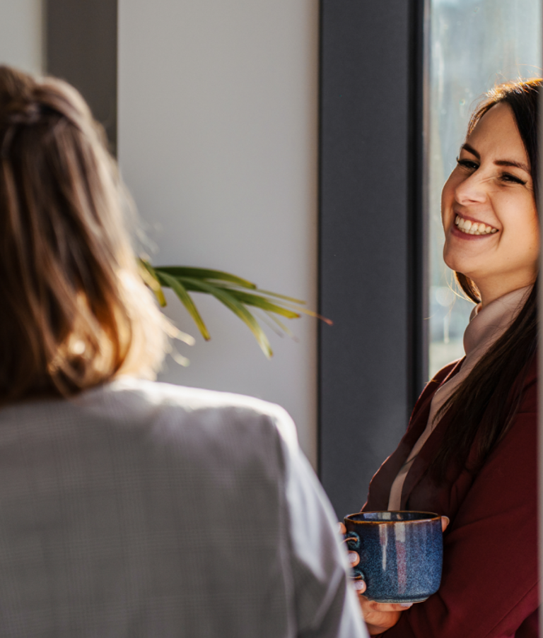 Women talking and smiling in a 7N office