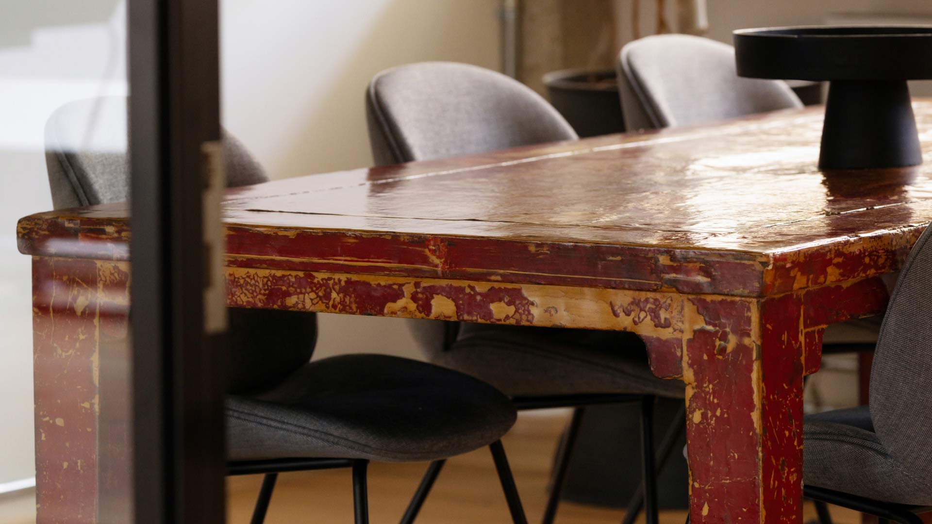 Red table with chairs in a meeting room in 7N's Aarhus office in Denmark. 