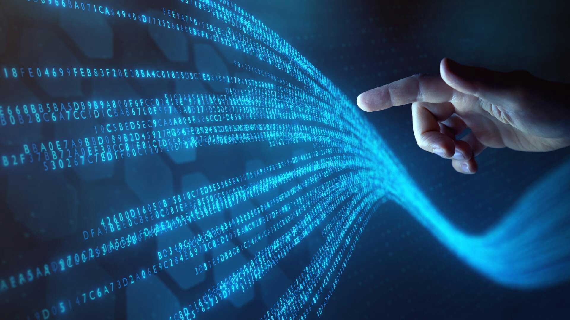 The hand of a man about to touch a stream of code