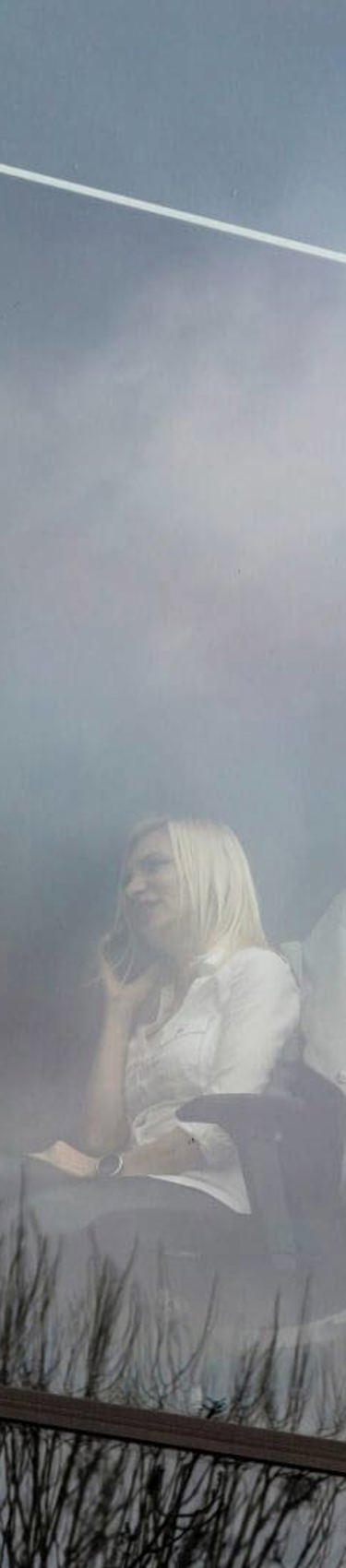 Woman in window of office talking on her phone