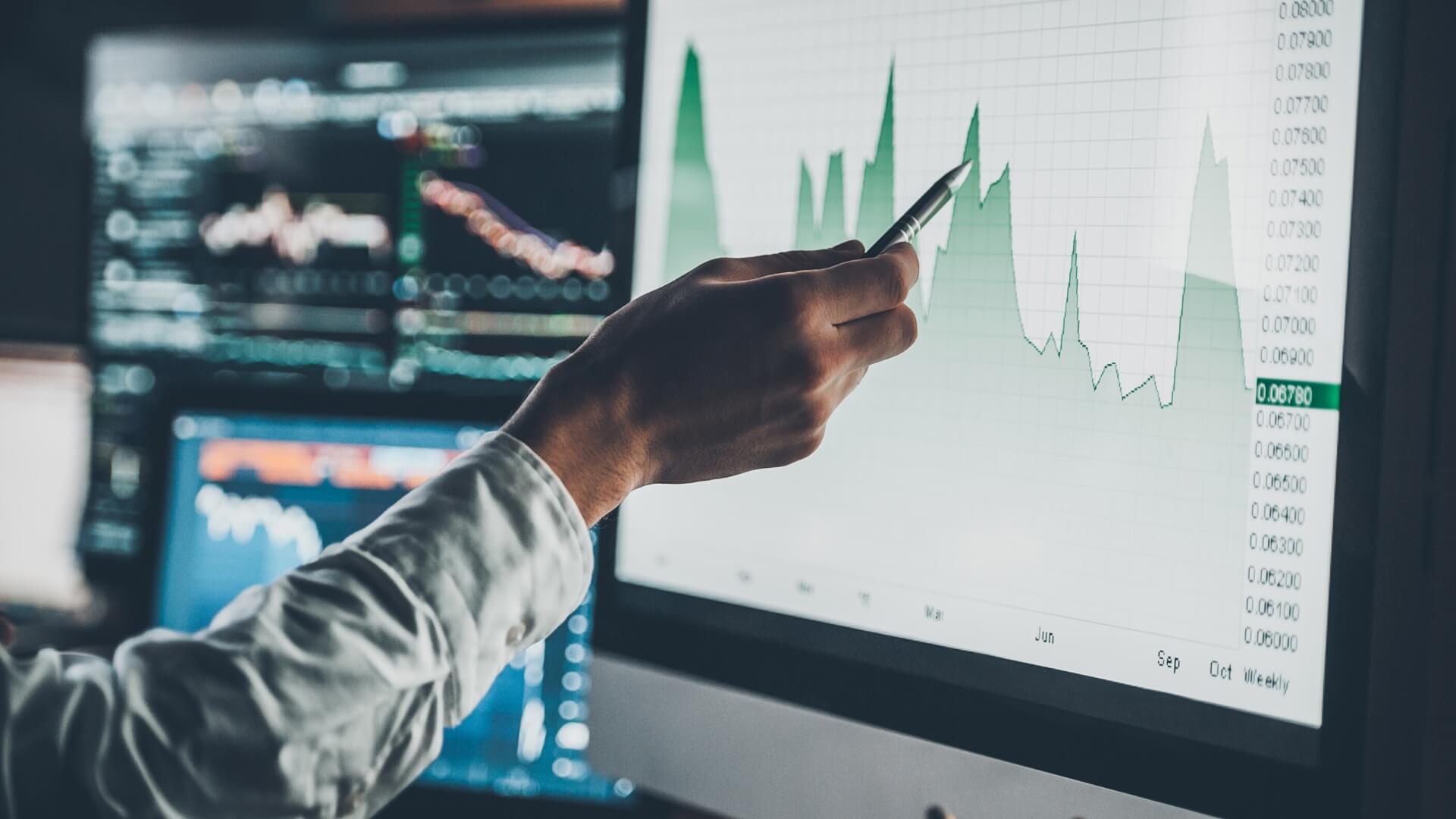 Man pointing to a screen with statistics