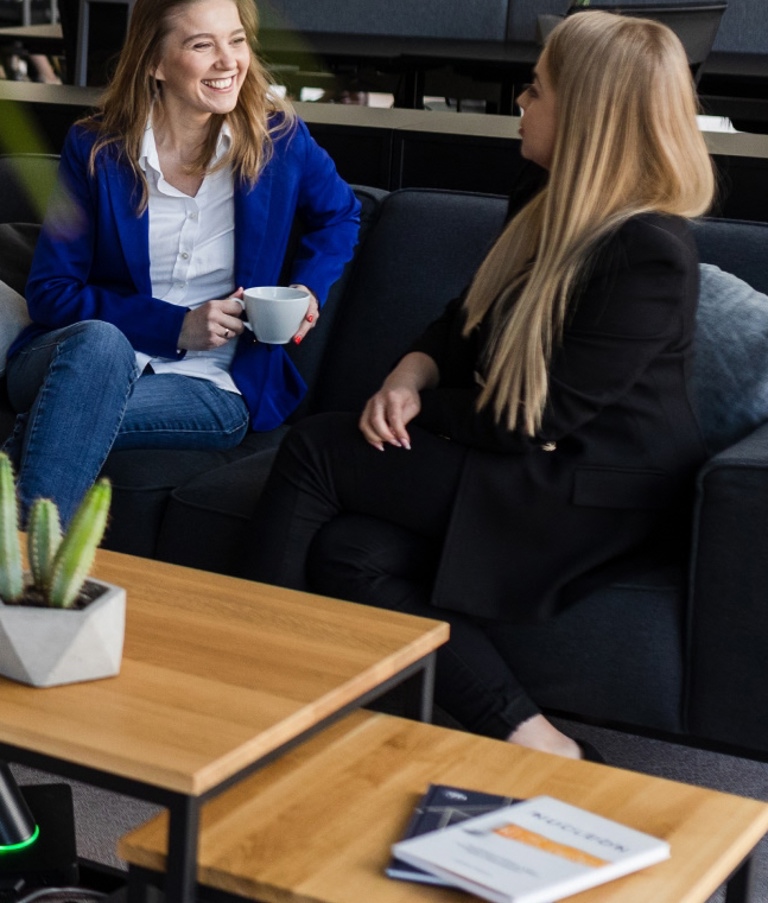 Four women sitting around table while talking