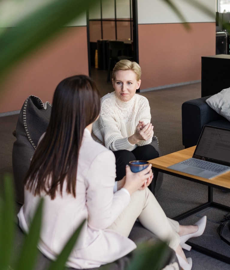 Four women sitting around table while talking