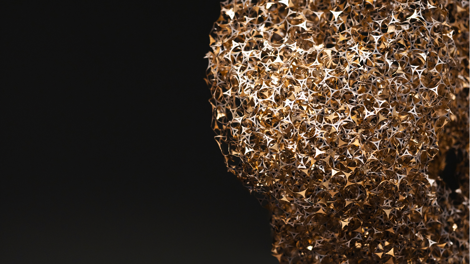 Dark background with golden sculpture in the front in the Copenhagen office in Denmark. 