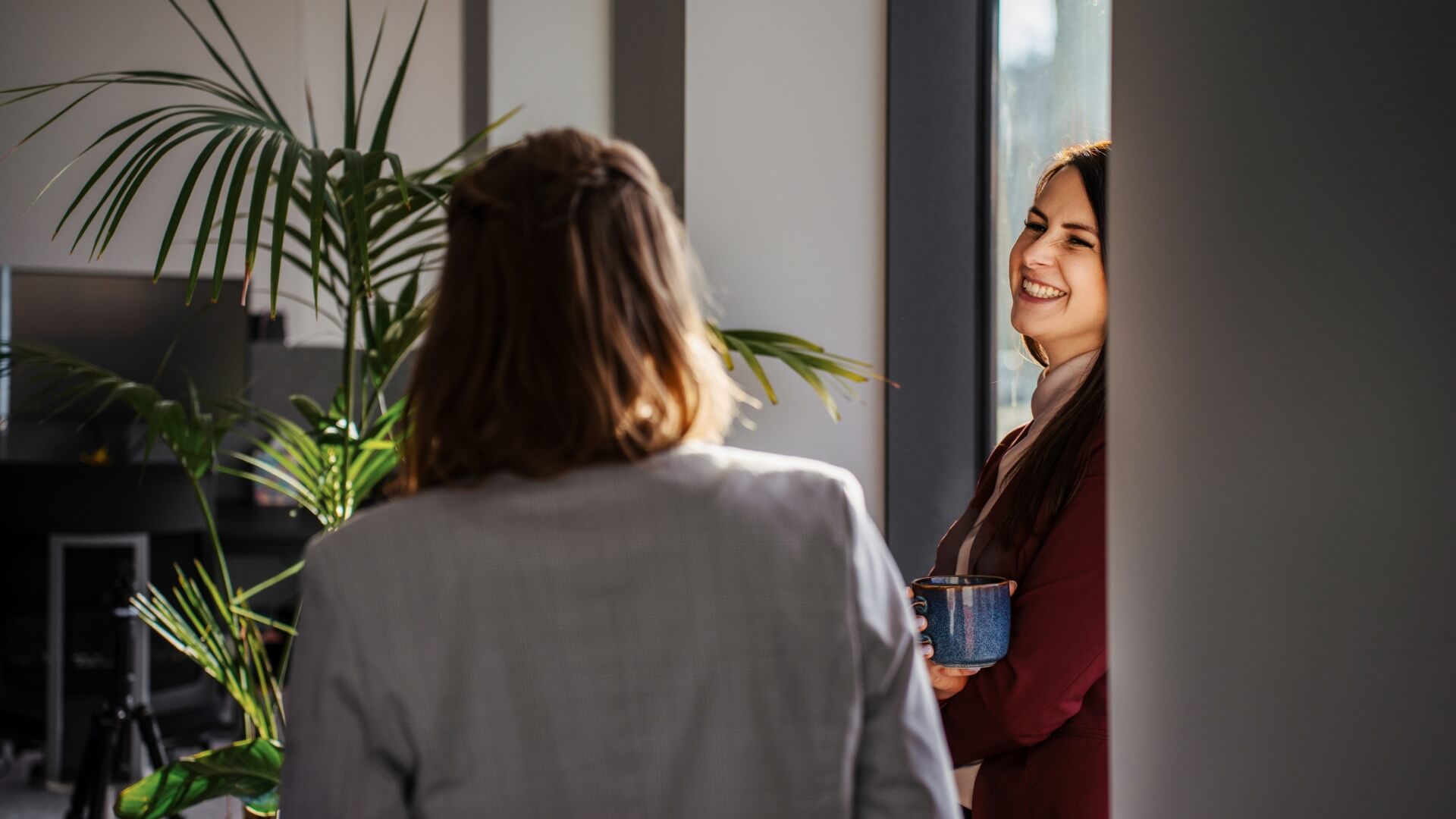 Women talking and smiling in the Gdansk office in Poland. 