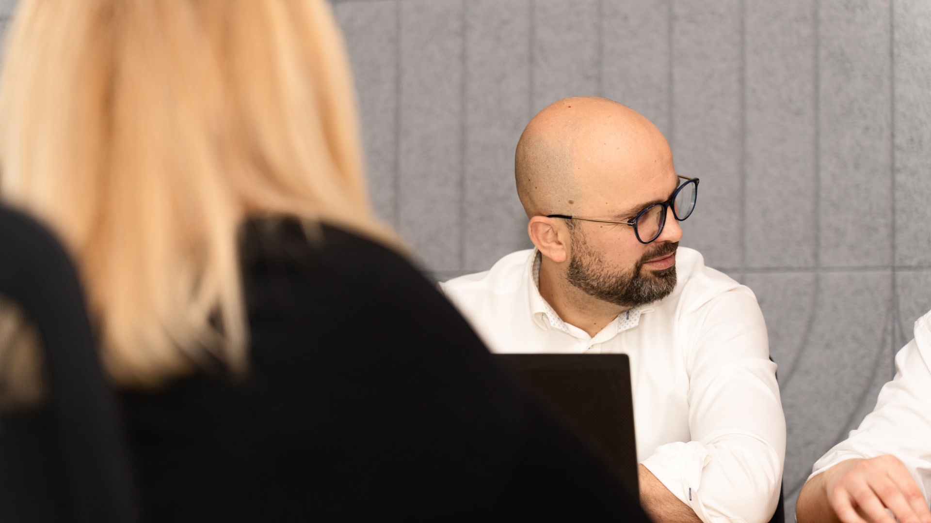 A man talking to another man while working on computer in the Warsaw office in Poland. 