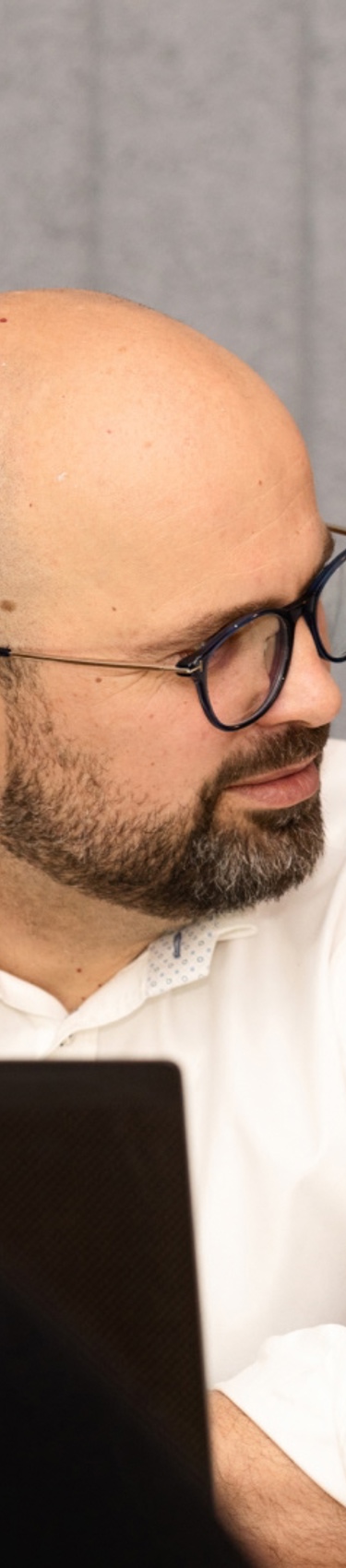 A man talking to another man while working on computer