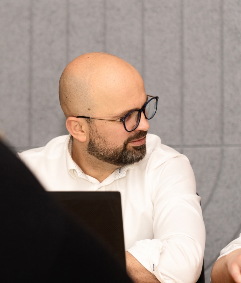 A man talking to another man while working on computer in the Warsaw office in Poland. 