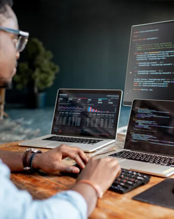 A man at his desk working on software on his computer