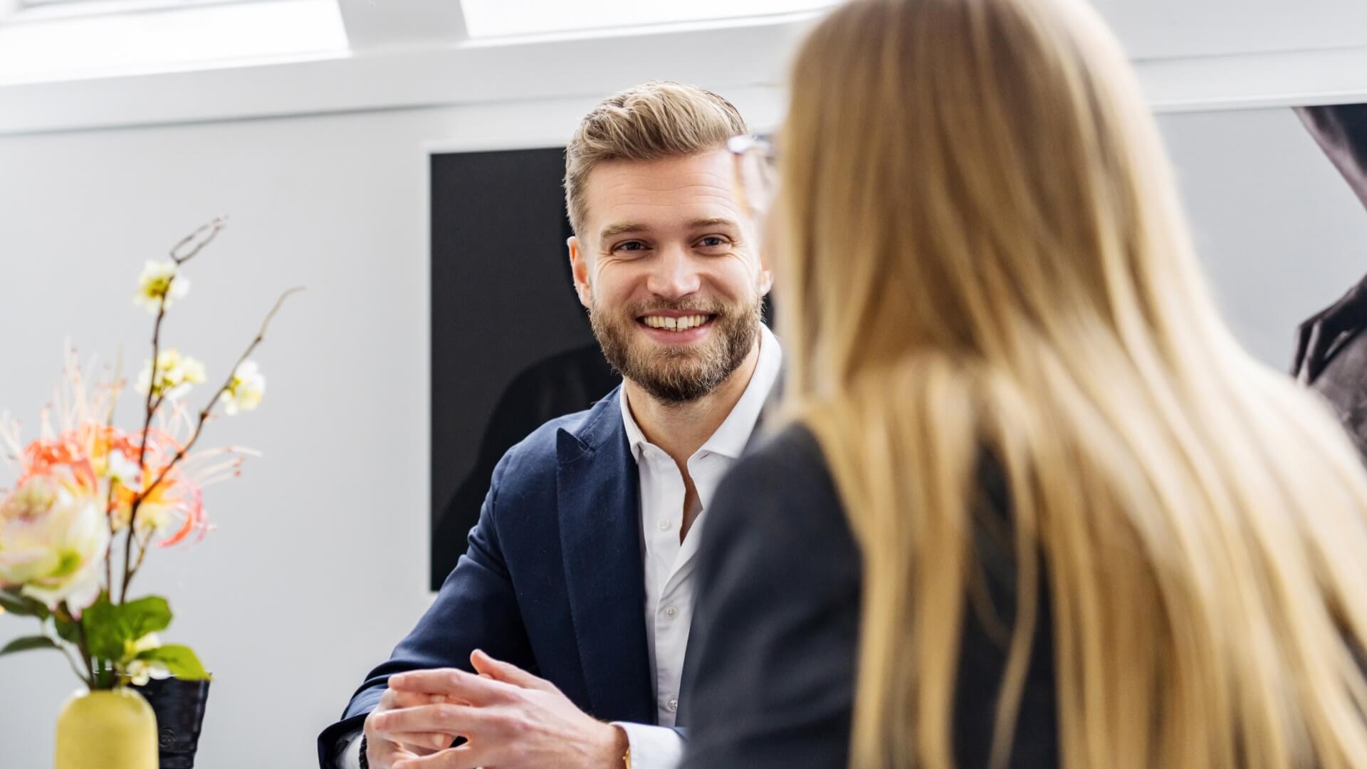 Man smiling at woman during a meeting in the 7N's Copenhagen office in Denmark 