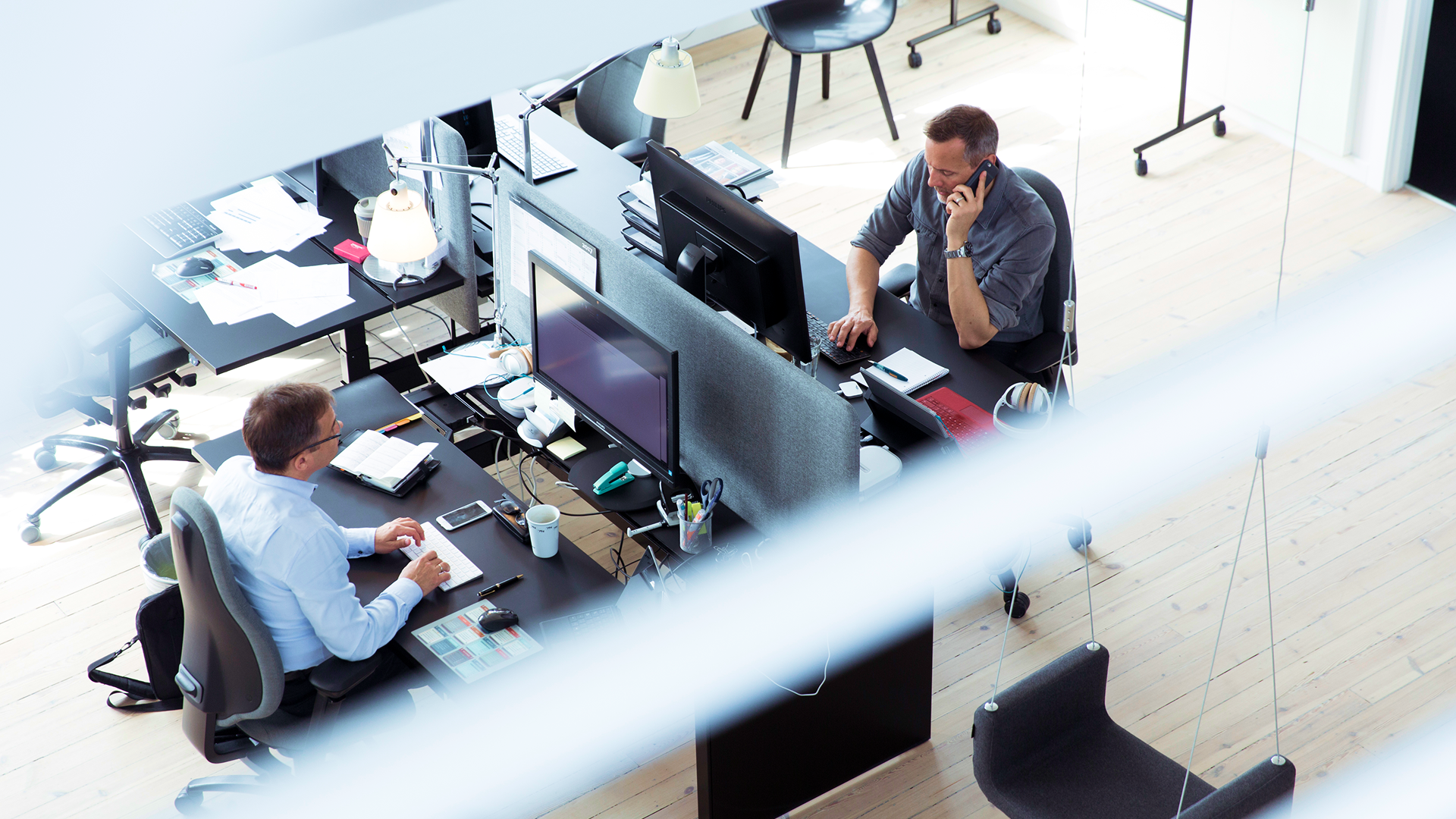 Two men working at computers seen from above in the Copenhagen office in Denmark. 