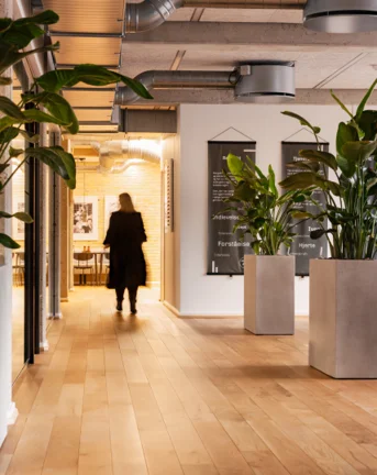 Aarhus office with a woman walking in the background on a beige floor