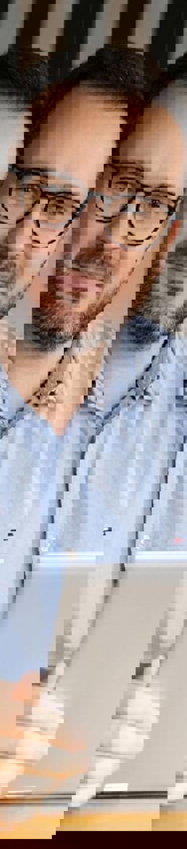 Man sitting in an office with a computer in the Warsaw office in Poland. 