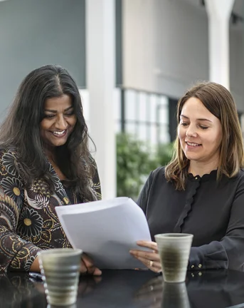Two female 7N staff members looking at some paper