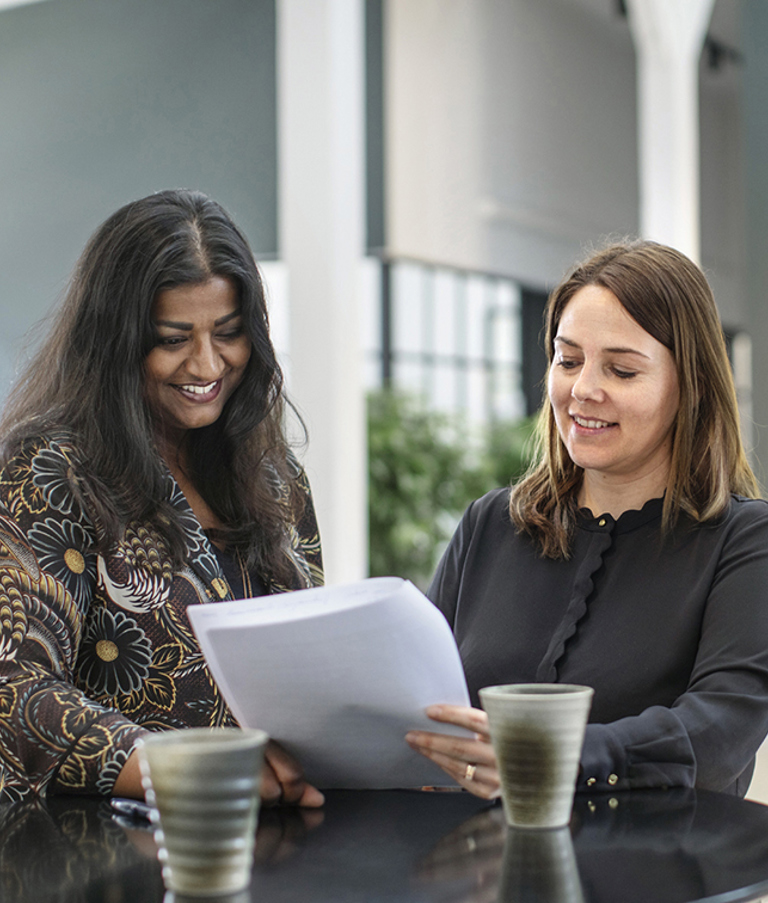 Two female 7N staff members looking at some paper