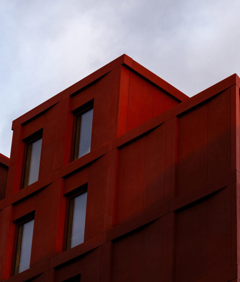 Tall red building with windows and blue sky