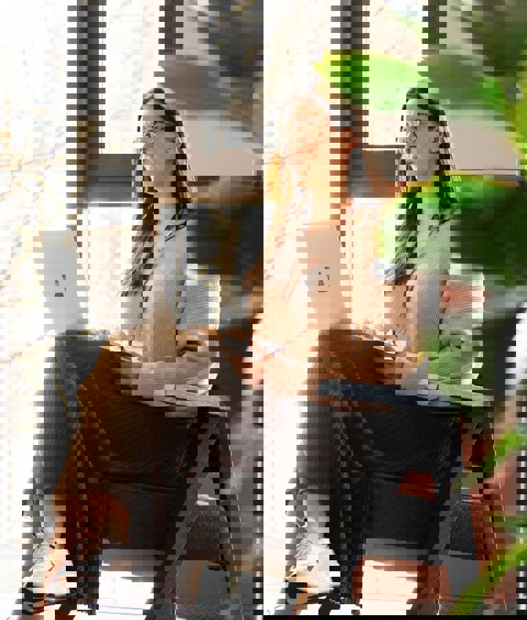 A woman working on her computer while sitting in a chair in the Gdansk Office in Poland.