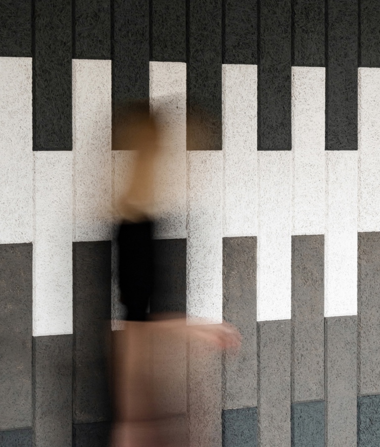 A woman walking past striped wall in 7N's Warsaw office