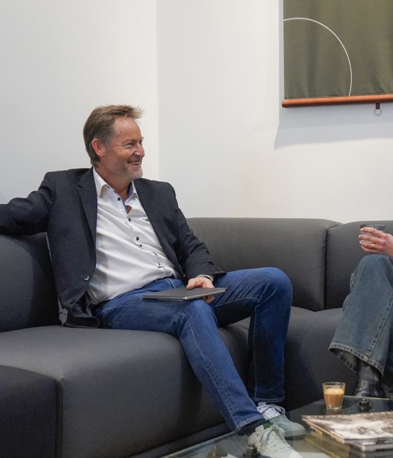 Woman and man sitting in sofa talking in the Copenhagen office in Denmark. 