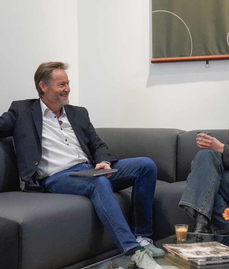 Woman and man sitting in sofa talking in the Copenhagen office in Denmark. 