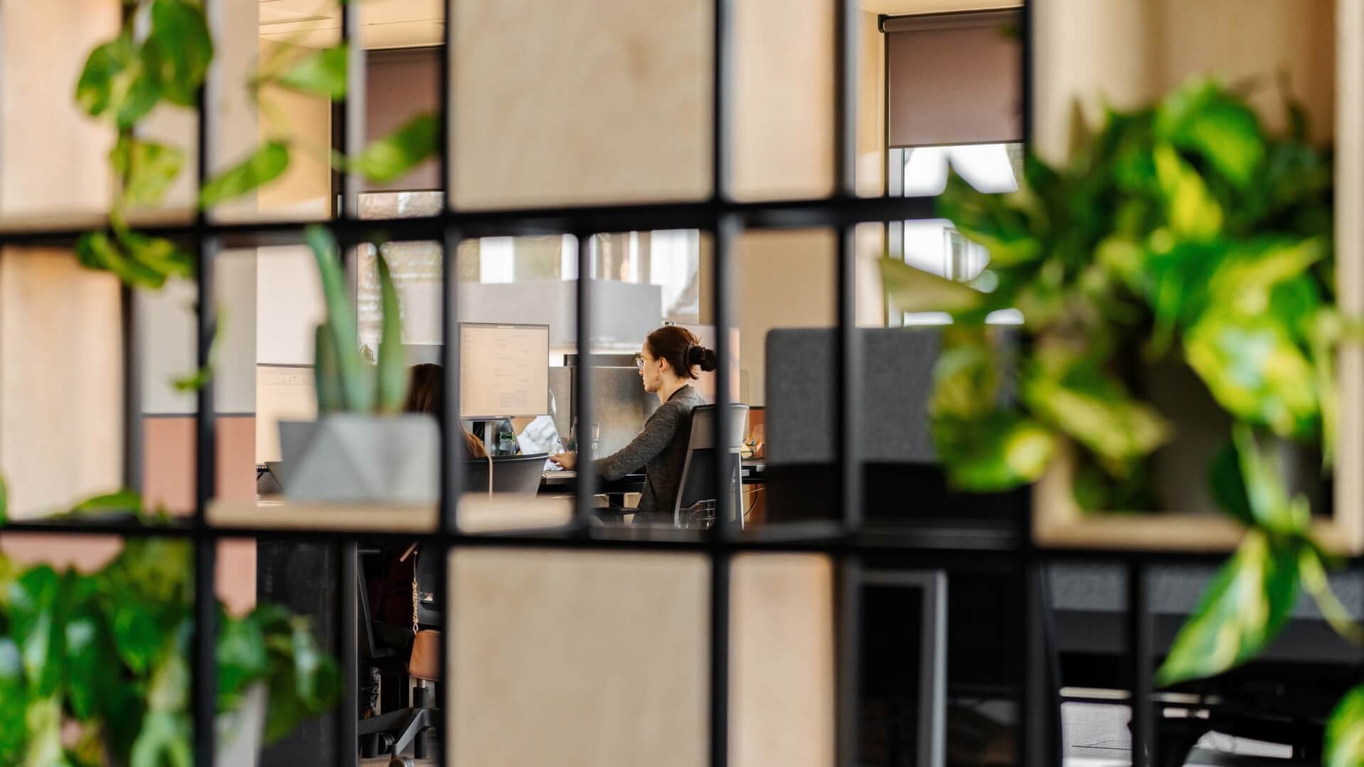 Woman working at office seen through squares in the Warsaw office in Poland. 
