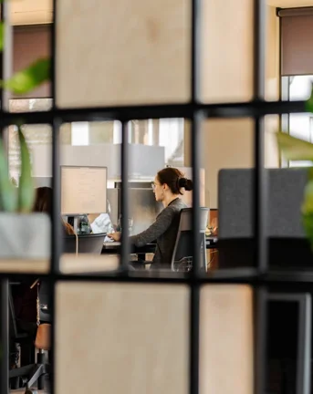 Woman working at office seen through squares