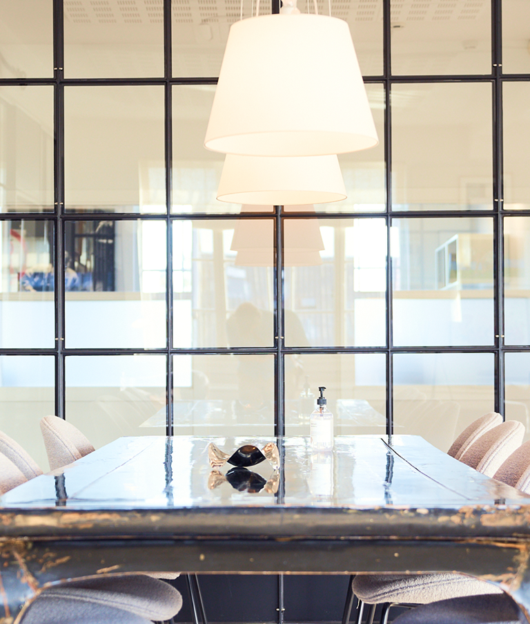Large wooden table in an office with a glass wall in the Copenhagen Office in Denmark 