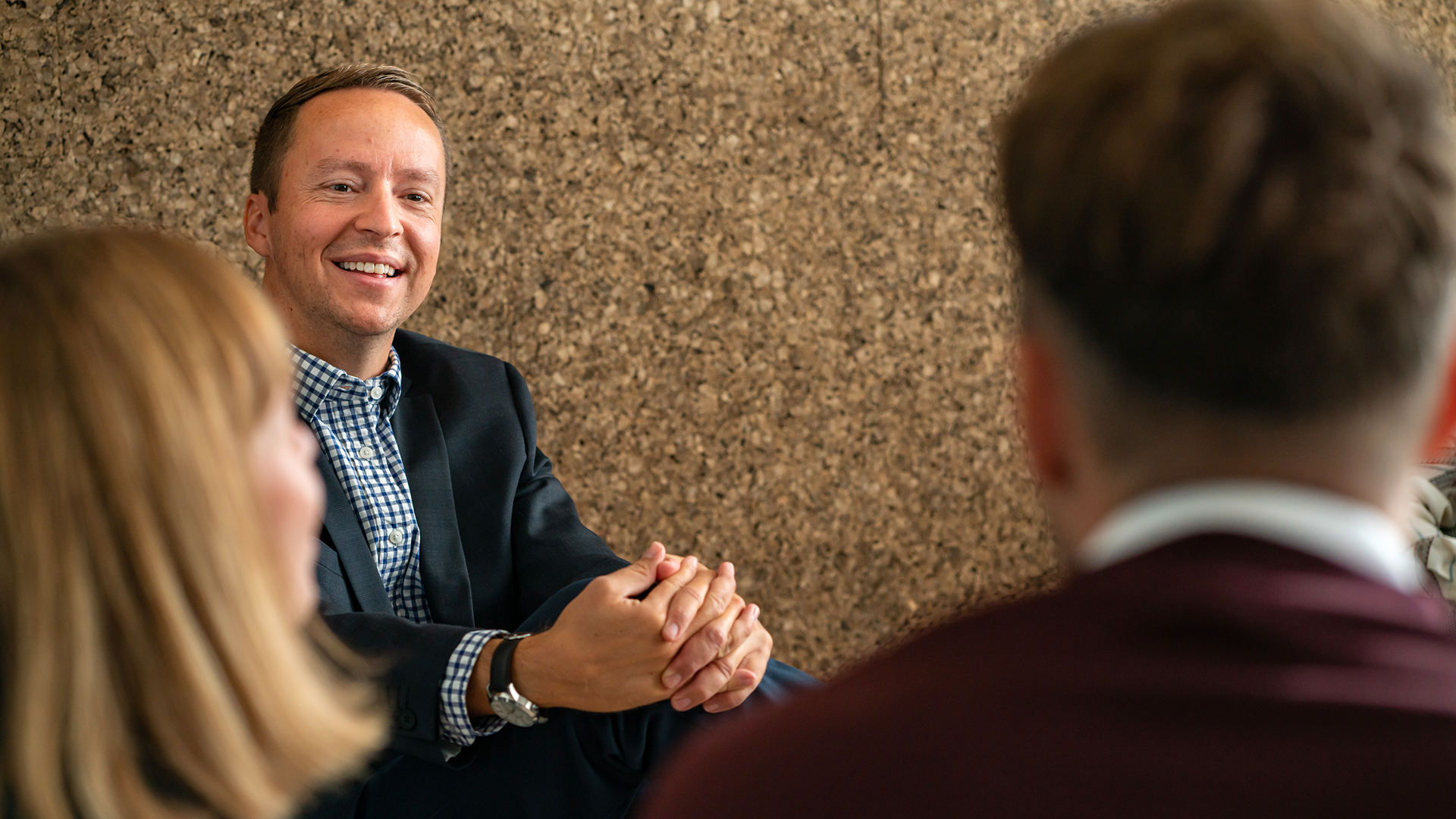 A man smiling while talking with two people in the Copenhagen office in Denmark 