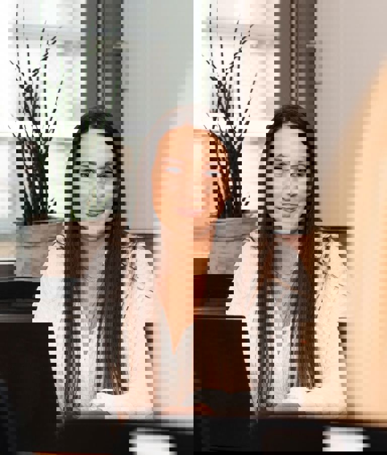 Woman at computer looking at another woman