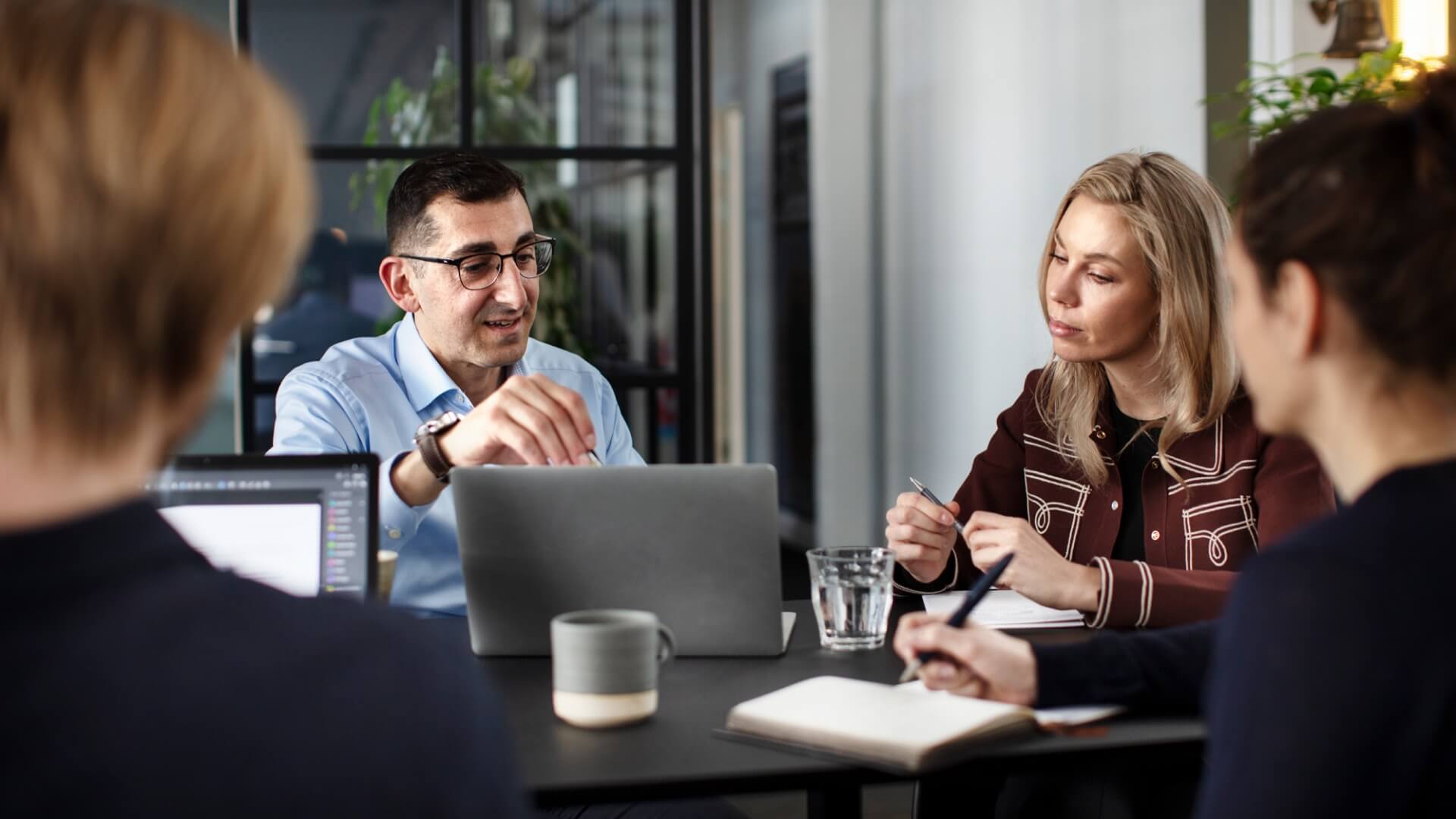 People sitting around a table in the Copenhagen office in Denmark during a meeting.