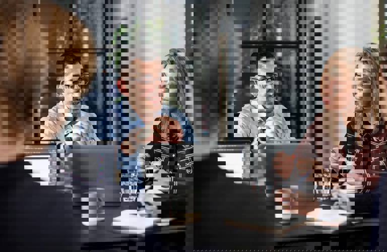 People sitting around a table in the Copenhagen office in Denmark during a meeting.