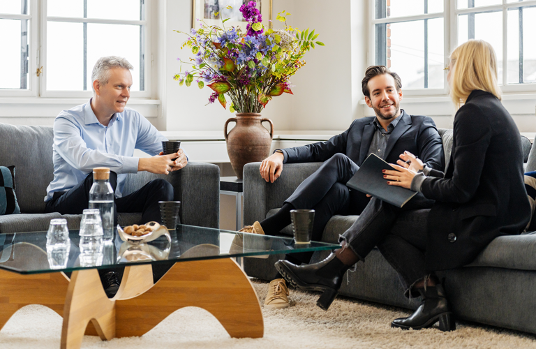 Two men and a woman talking while sitting in sofas in the Copenhagen office in Denmark