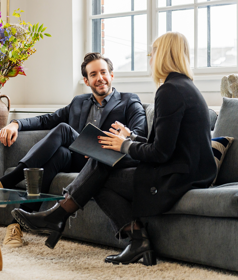 Two men and a woman talking while sitting in sofas 