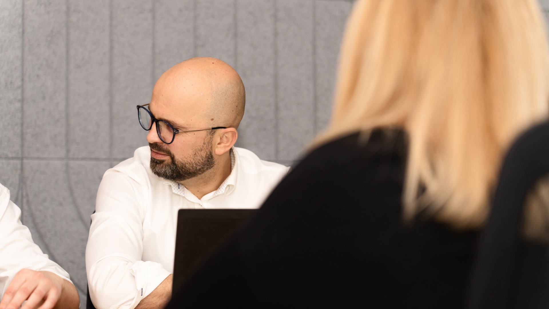 Man talking with another man while working on computer in the Warsaw office in Poland. 