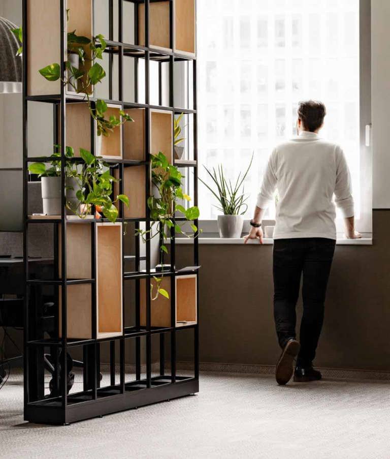 A man in the Warsaw office, Poland, looking out the window. 